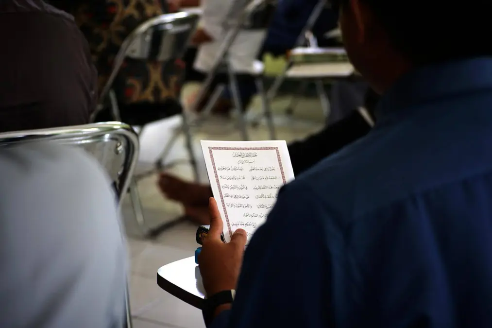 Étudiant lisant un texte arabe en classe