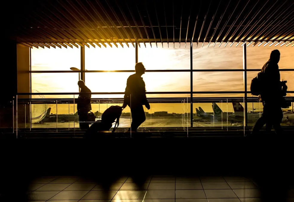 Voyageurs dans un aéroport au coucher du soleil