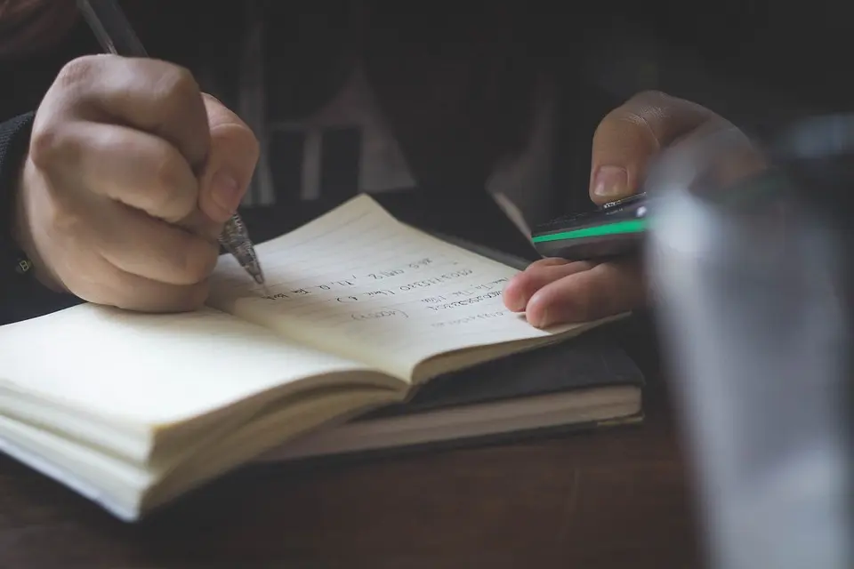 Person writing while learning the basics of Arabic