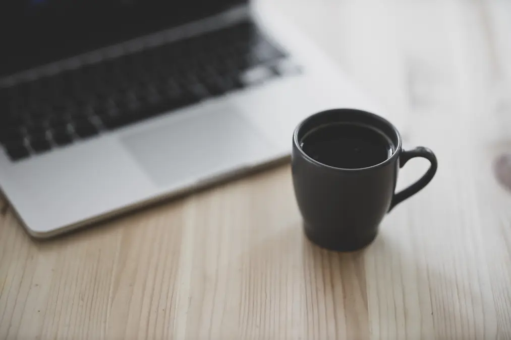 Tasse de café près d’un ordinateur portable