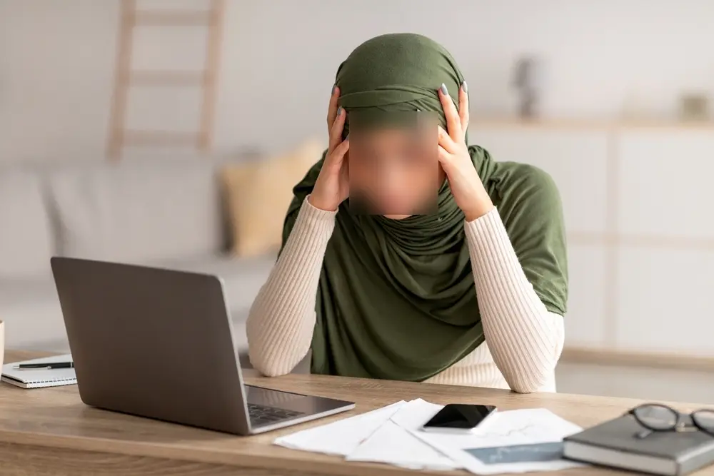 Femme stressée devant un ordinateur, illustrant l’anxiété