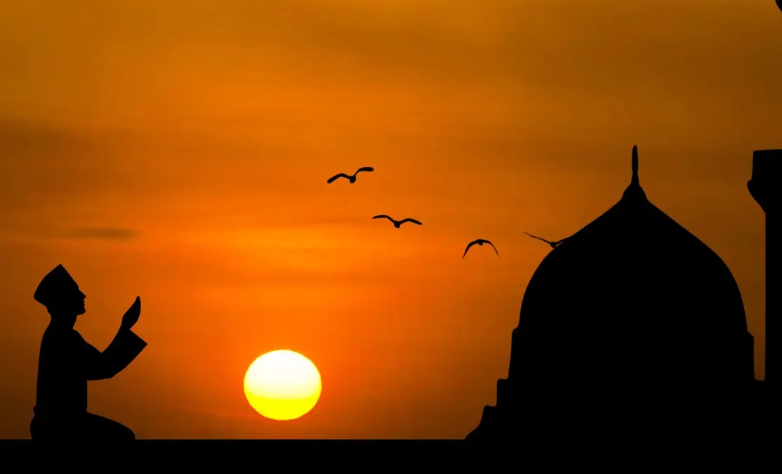 Silhouette d’un homme en invocation au coucher du soleil