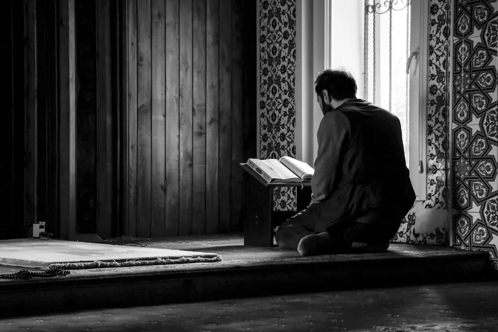 Student reading an Arabic book in a mosque