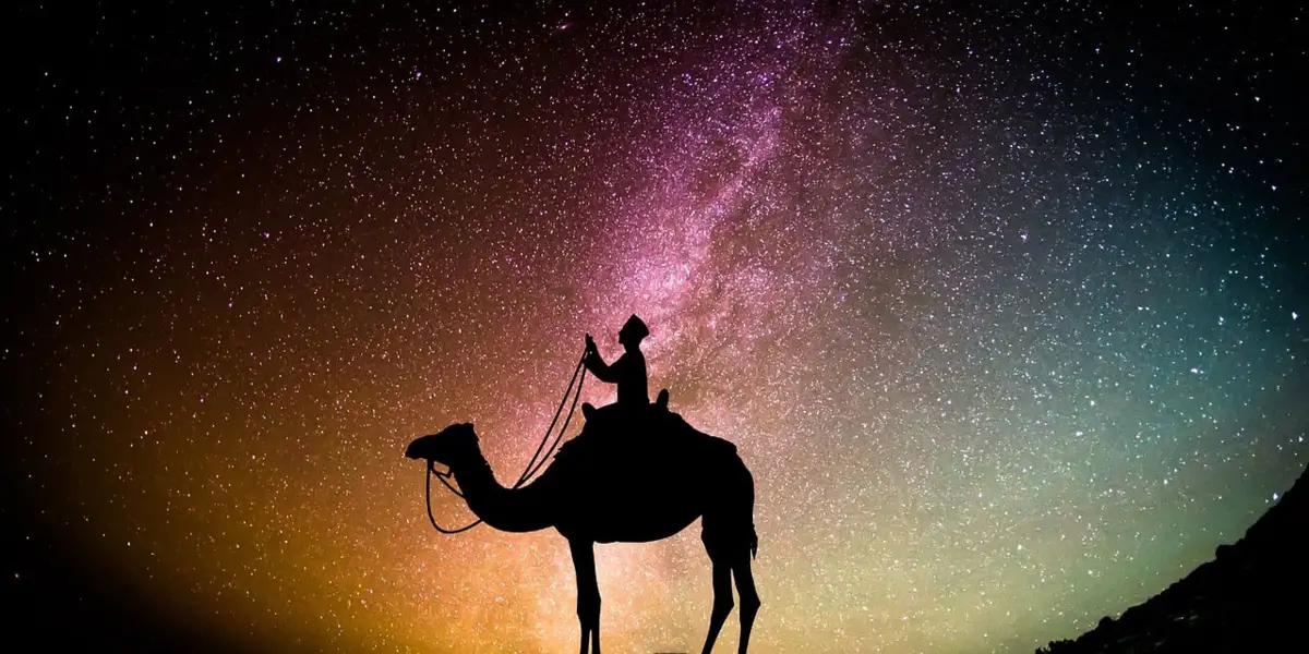 Voyageur avec chameau sous ciel étoilé