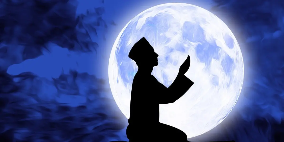 Silhouette en prière devant la lune pour ses parents défunts