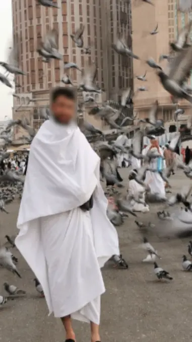 Pèlerin musulman récitant le Coran devant la Kaaba durant la Omra dans une atmosphère spirituelle apaisante