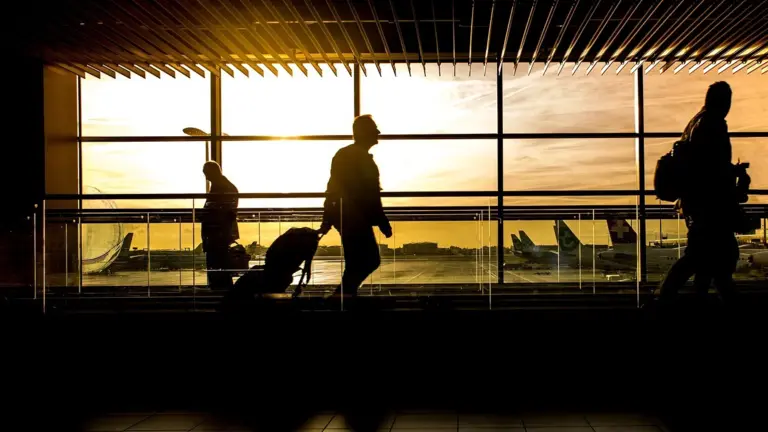 Voyageurs dans un aéroport au coucher du soleil