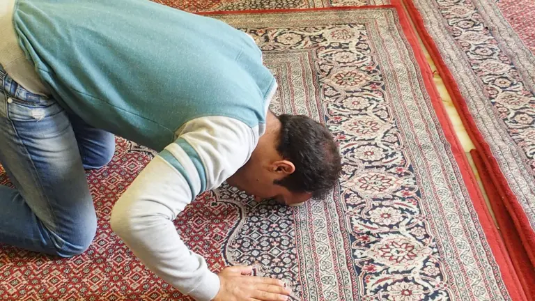 Mann wirft sich beim Gebet auf einem Gebetsteppich nieder