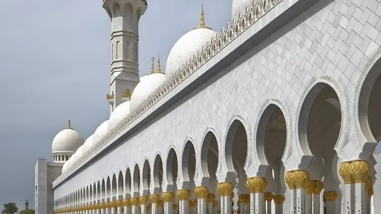 White mosque with minaret and domes in the United Arab Emirates