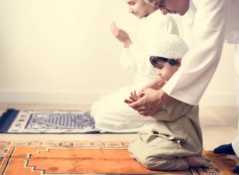 Enfant apprenant la prière avec son père