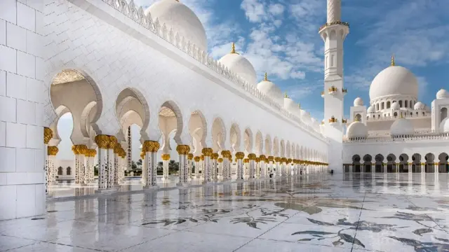 White mosque with courtyard and minaret