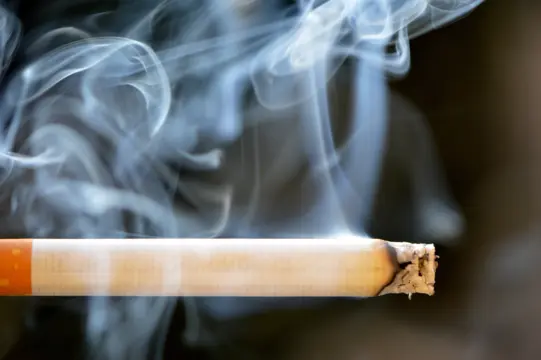 Lit cigarette with tobacco smoke