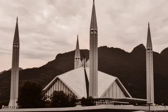 Modern mosque with minarets before mountains