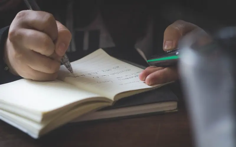 Personne écrivant pour apprendre les bases de l’arabe