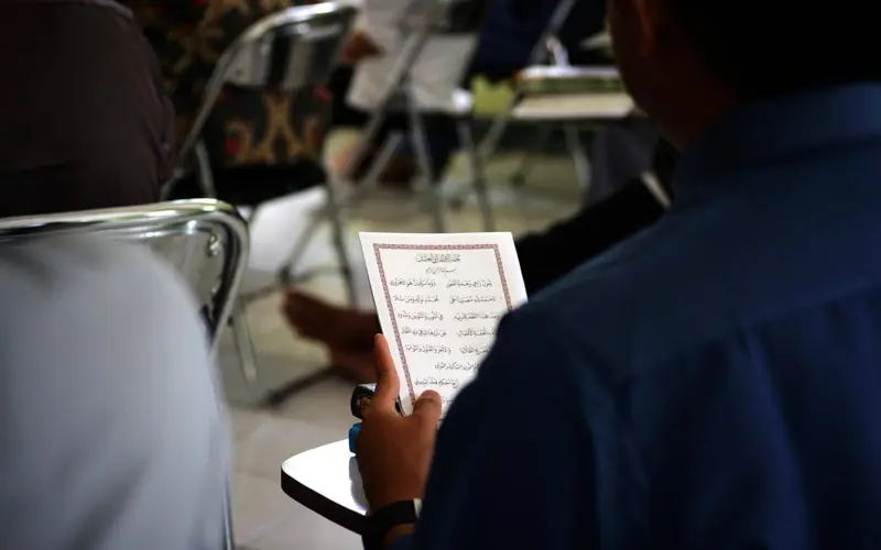 Student reading Arabic text in class