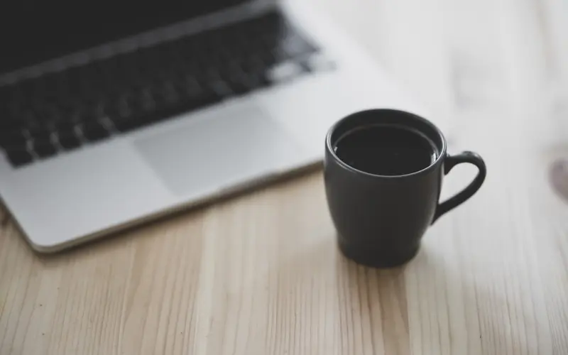 Cup of coffee near a laptop computer