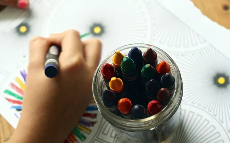 Child drawing with colorful markers