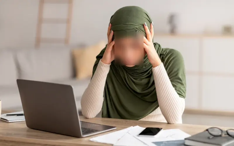 Stressed woman at a laptop, illustrating anxiety