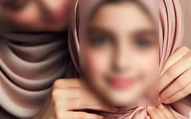 Mother helping her daughter wear the hijab