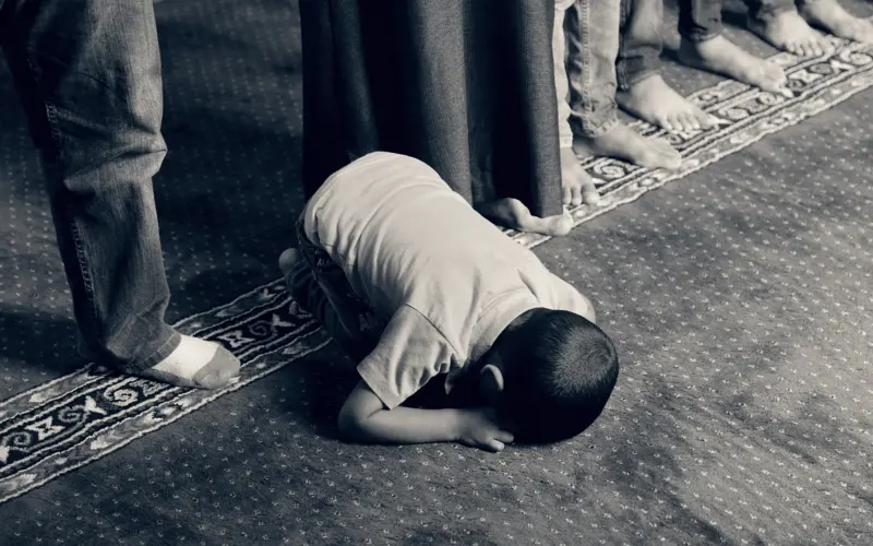 Muslim prostrating in prayer on a prayer mat