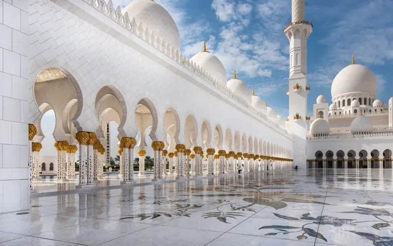 White grand mosque with bright arches and domes
