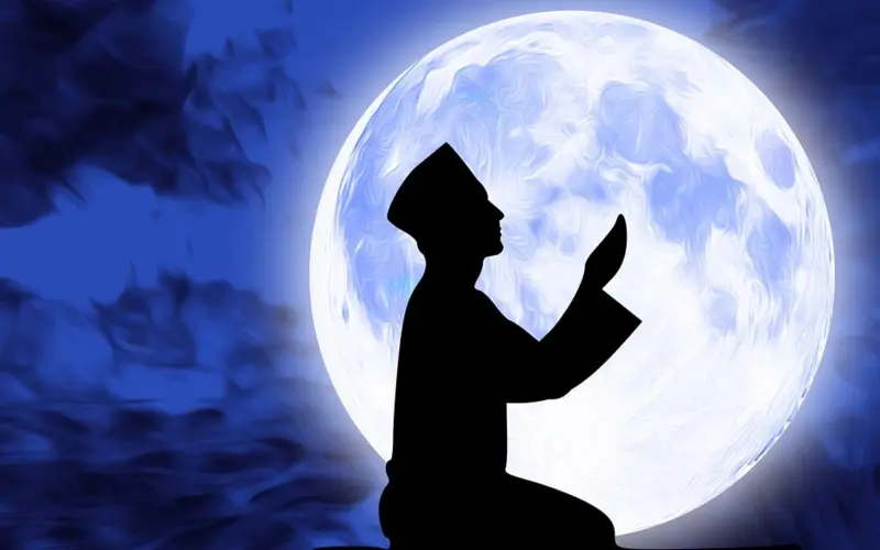 Silhouette praying before the moon for deceased parents