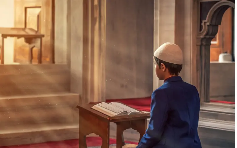 Child reading the Quran in a mosque