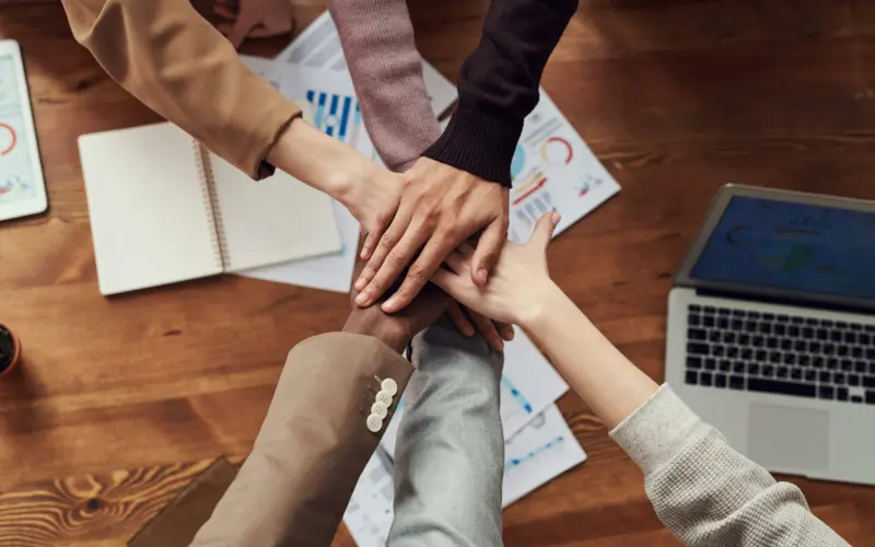 Professional team joining hands at the office