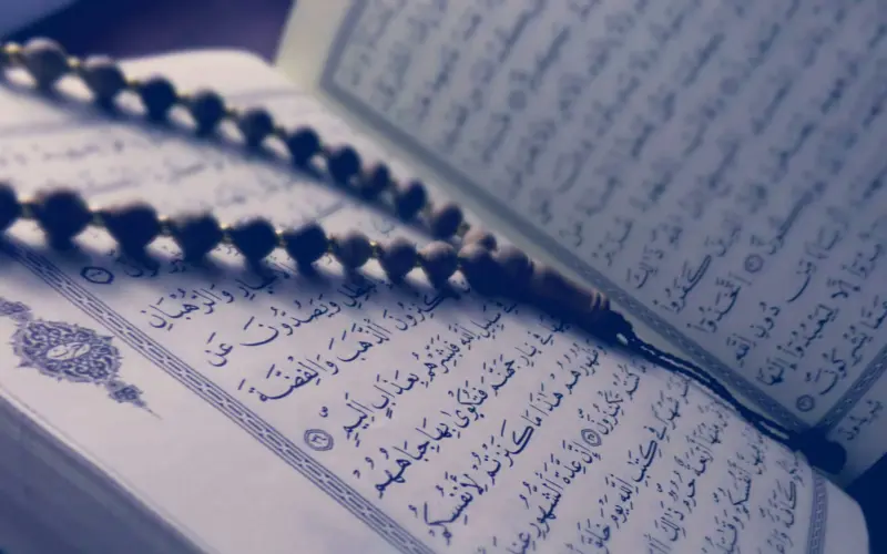 Open Quran with prayer beads illustrating online tafsir study