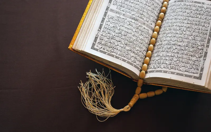 Open Quran with prayer beads for Tafsir study