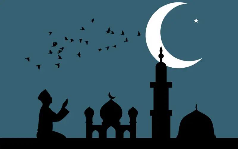 Man praying near a mosque under the moon