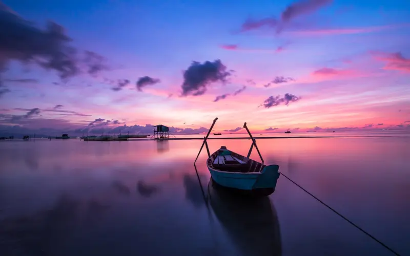 Boat on calm water at sunrise