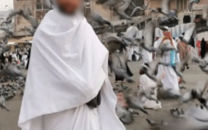 Muslim pilgrim reciting the Quran in front of the Kaaba during Umrah in a peaceful spiritual atmosphere