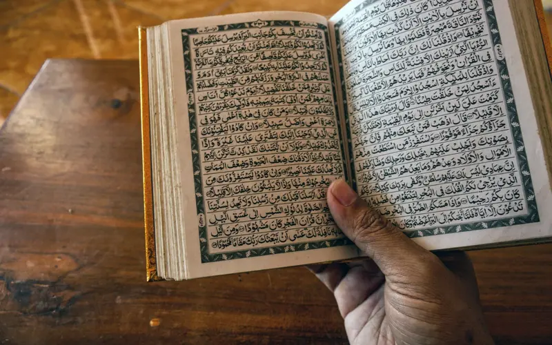 Open Quran held in hand for online learning
