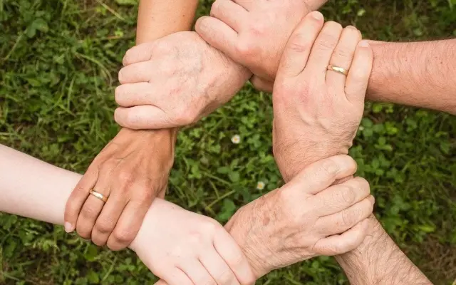 Hände mehrerer Generationen bilden einen Kreis