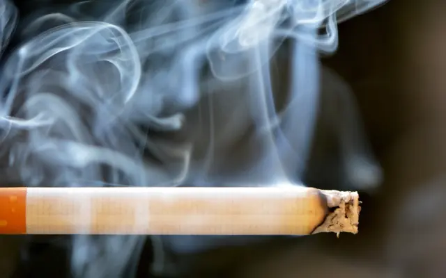 Cigarette allumée avec fumée de tabac