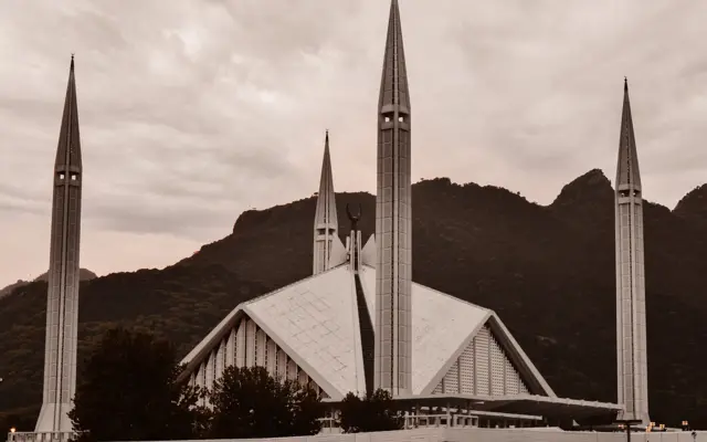 Mosquée moderne avec minarets devant des montagnes