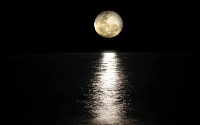 Vollmond spiegelt sich nachts im Meer