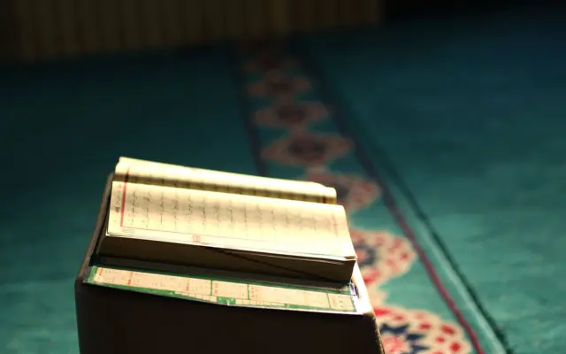 Geöffneter Koran auf einem Gebetsteppich