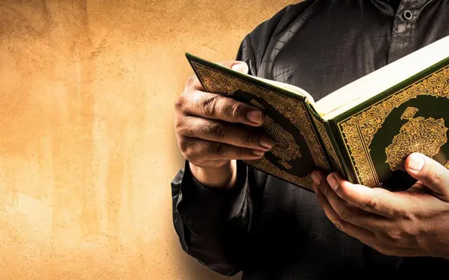 Pèlerin récitant le Coran en arabe pendant la Omra pour renforcer la baraka et la connexion spirituelle avec Allah
