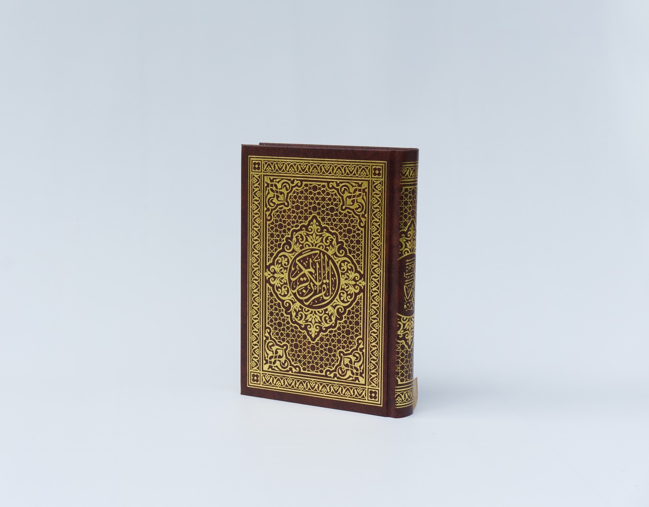 Closed Quran placed on a white background