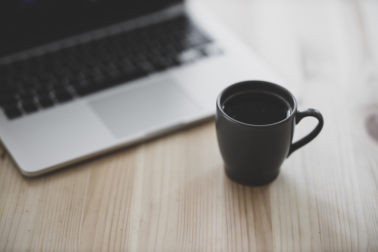 Cup of coffee near a laptop computer