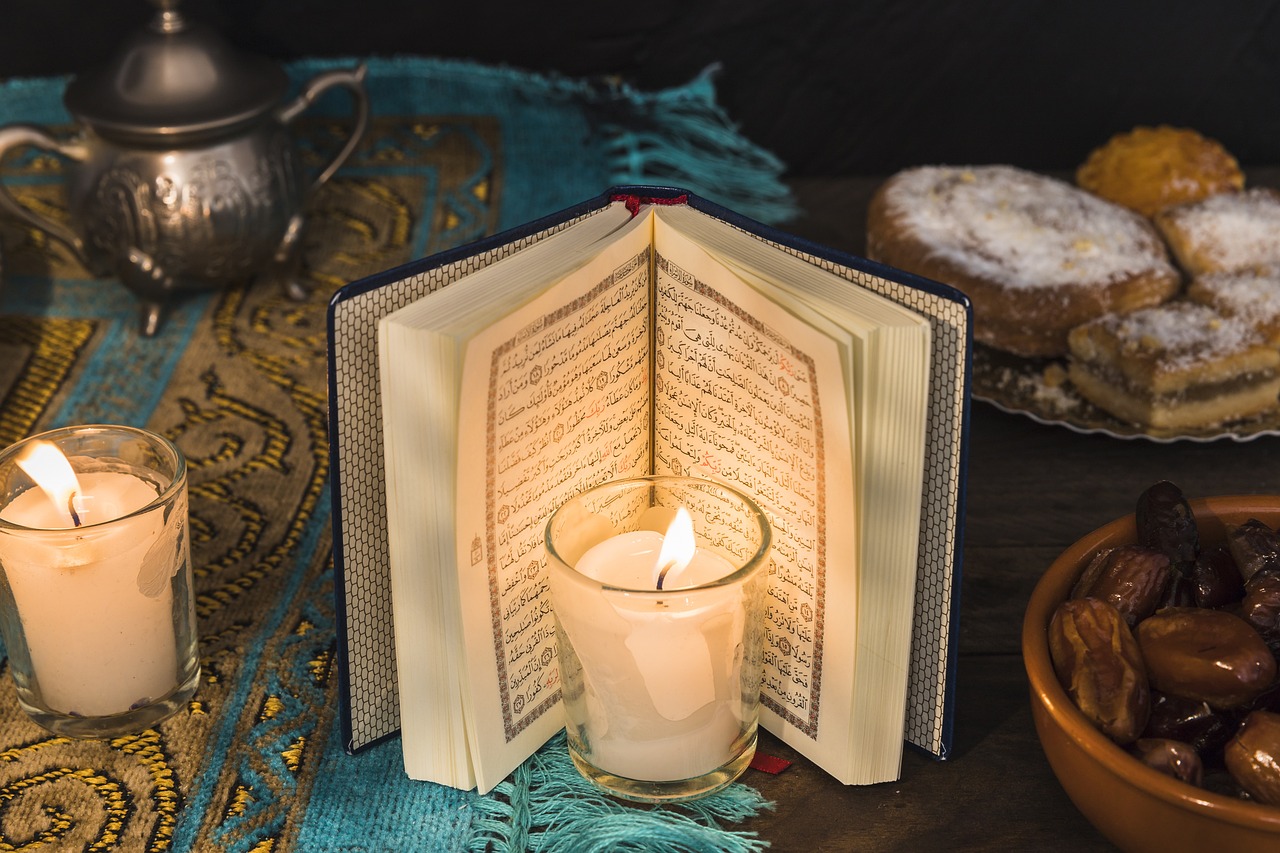 Open Quran with candle and dates