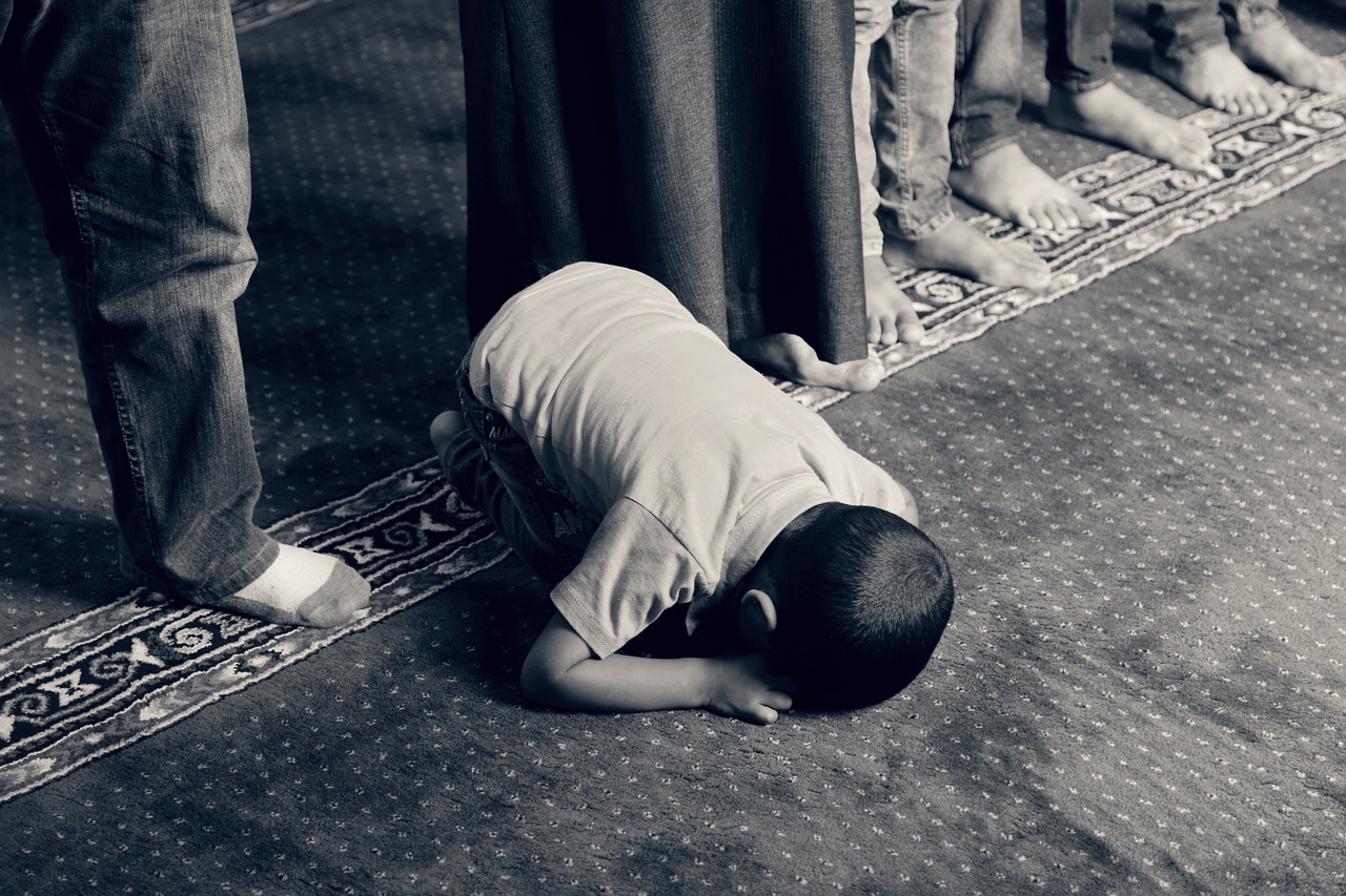 Muslim prostrating in prayer on a prayer mat