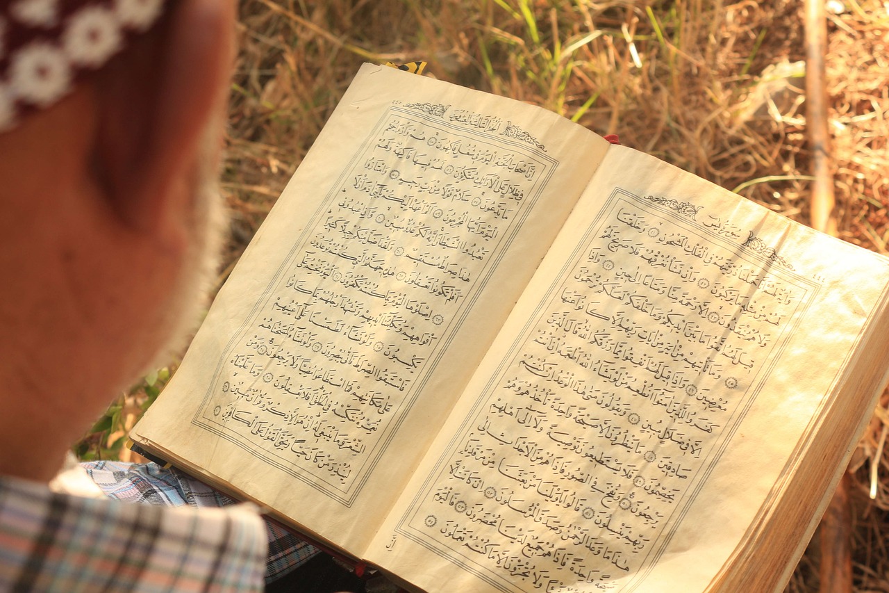 Person reading the Quran outdoors