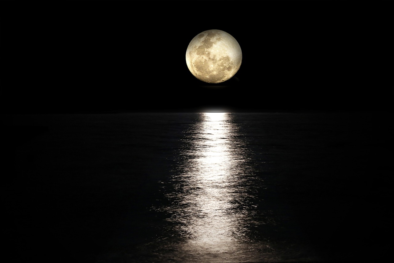 Pleine lune se reflétant sur la mer la nuit