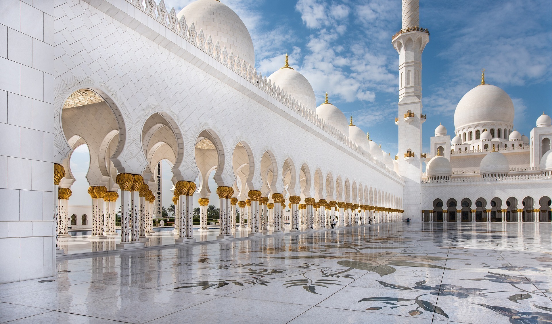 White grand mosque with bright arches and domes