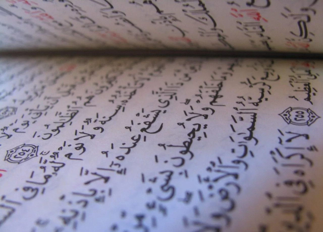 Page du Coran ouverte avec écriture arabe