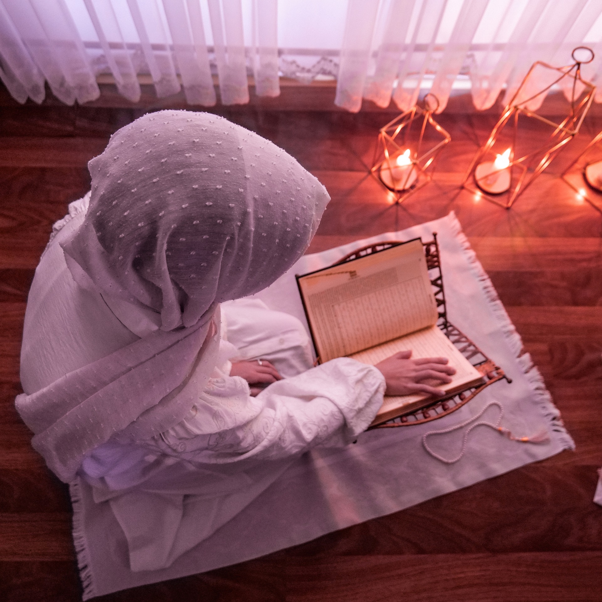 Woman reading the Quran in a prayer space